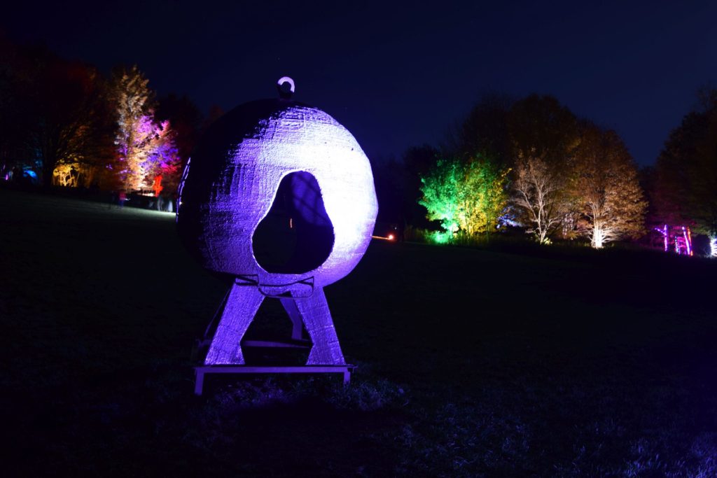 steel sculptures bathed in LED lights at sculpture park on an autumn evening